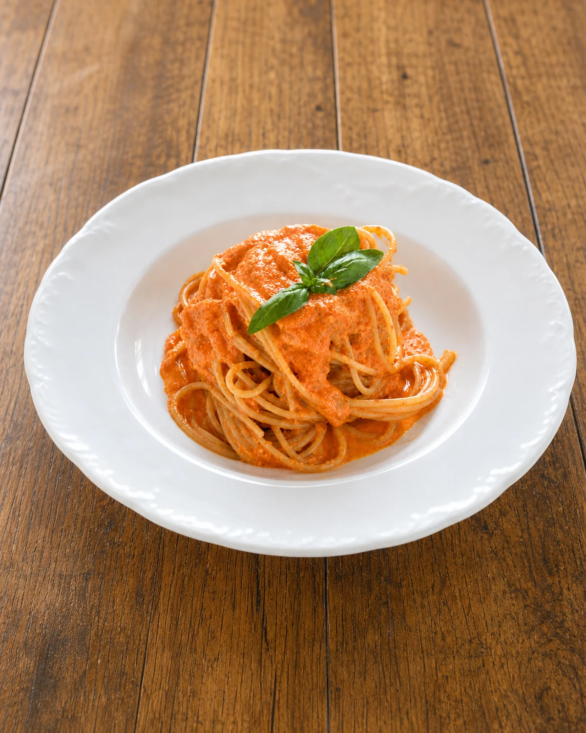 Whole white bowl of spaghetti with creamy ricotta and tomato sauce